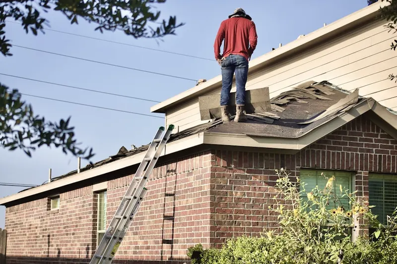 Professional roofer working on a residential roof in Mahaffie